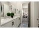 Bathroom with dual sinks, white cabinets and hardware, vanity, and views to office space at 21387 W Meadowbrook Ave, Buckeye, AZ 85396