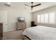This is a bedroom featuring plantation shutters, a ceiling fan, and dressers for storage at 21387 W Meadowbrook Ave, Buckeye, AZ 85396