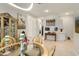 A dining room showcases glass table, elegant decor, and a stylish cabinet, blending style and functionality at 21387 W Meadowbrook Ave, Buckeye, AZ 85396