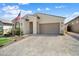Inviting single-story home featuring a well-maintained yard, a quaint porch, and a two-car garage at 21387 W Meadowbrook Ave, Buckeye, AZ 85396