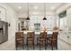 Modern kitchen featuring white cabinetry, a spacious island with seating, and stainless-steel appliances at 21387 W Meadowbrook Ave, Buckeye, AZ 85396