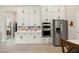 A well-organized kitchen features stainless steel appliances, white cabinetry, and stylish tile backsplash at 21387 W Meadowbrook Ave, Buckeye, AZ 85396