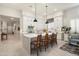 Bright kitchen with white cabinetry, a large island with seating, and contemporary pendant lighting at 21387 W Meadowbrook Ave, Buckeye, AZ 85396