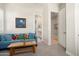 Casual living area with comfortable blue sofa and views to hallway and bathroom at 21387 W Meadowbrook Ave, Buckeye, AZ 85396