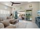 Cozy living room with a large sectional sofa, media console, and direct access to a covered outdoor patio at 21387 W Meadowbrook Ave, Buckeye, AZ 85396