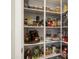 A well-stocked pantry features organized shelving filled with a variety of dry goods, canned items and condiments at 21387 W Meadowbrook Ave, Buckeye, AZ 85396