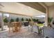 Covered patio area with cushioned outdoor seating, dining table, and BBQ at 21387 W Meadowbrook Ave, Buckeye, AZ 85396