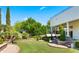 Expansive backyard with manicured lawn, elegant landscaping, and a covered patio, perfect for outdoor enjoyment at 2174 E Avenida Del Valle Ct, Gilbert, AZ 85298
