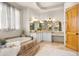 Elegant bathroom features a tiled tub surround, double sinks, and warm lighting at 2174 E Avenida Del Valle Ct, Gilbert, AZ 85298