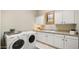 Bright laundry room featuring a washer and dryer, ample cabinetry and counter space, and neutral tones at 2174 E Avenida Del Valle Ct, Gilbert, AZ 85298