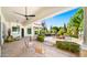 Covered patio with ceiling fan, elegant seating, and views of the pool, spa, and outdoor fireplace at 2174 E Avenida Del Valle Ct, Gilbert, AZ 85298
