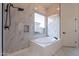 Bathroom featuring a soaking tub, separate shower, and elegant marble-tiled walls at 21913 N Pedregosa Ct, Sun City West, AZ 85375