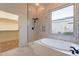 Luxurious bathroom with soaking tub, walk-in closet, and marble-tiled shower for a spa-like experience at 21913 N Pedregosa Ct, Sun City West, AZ 85375