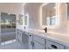 Modern bathroom featuring a double vanity, marble countertops, and a view to the bedroom at 21913 N Pedregosa Ct, Sun City West, AZ 85375