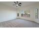 Spacious bedroom featuring large windows, plush carpet, and ceiling fan for comfortable living at 21913 N Pedregosa Ct, Sun City West, AZ 85375