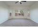 Bedroom boasting neutral carpet, ceiling fan, and great backyard views from the bay windows at 21913 N Pedregosa Ct, Sun City West, AZ 85375