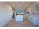 Bright kitchen with stainless steel appliances, white cabinetry, a large marble island, and hardwood floors at 21913 N Pedregosa Ct, Sun City West, AZ 85375