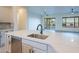 Stylish kitchen island featuring a stainless steel sink, modern faucet, and white quartz countertop at 21913 N Pedregosa Ct, Sun City West, AZ 85375