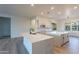 Modern kitchen with white cabinetry, quartz countertops, stainless steel appliances, and a large island at 21913 N Pedregosa Ct, Sun City West, AZ 85375