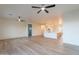 Spacious living area featuring an open floor plan with a view of the kitchen, modern fans, and neutral decor at 21913 N Pedregosa Ct, Sun City West, AZ 85375
