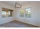 Bright living room with hardwood floors and a modern chandelier, offering ample natural light through the windows at 21913 N Pedregosa Ct, Sun City West, AZ 85375