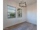Bright living room with hardwood floors and a modern chandelier, offering ample natural light through the windows at 21913 N Pedregosa Ct, Sun City West, AZ 85375