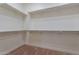 Spacious walk-in closet featuring carpeted flooring and shelving at 21913 N Pedregosa Ct, Sun City West, AZ 85375