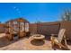 Backyard greenhouse with wood chairs and firepit offers a tranquil outdoor space at 23306 S 221St St, Queen Creek, AZ 85142