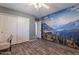 This bedroom features a ceiling fan, wood floors, and mountain-themed wallpaper at 23306 S 221St St, Queen Creek, AZ 85142