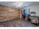 Bedroom boasts wood floors and accent wall, ceiling fan, desk and natural light at 23306 S 221St St, Queen Creek, AZ 85142