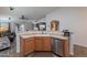 Functional kitchen featuring warm wood cabinets and stainless steel appliances, with an open view into the living room at 23306 S 221St St, Queen Creek, AZ 85142