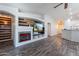 Spacious living room with a modern fireplace, wood-look floors, and open access to the dining and kitchen areas at 23306 S 221St St, Queen Creek, AZ 85142