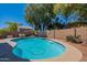 Inviting backyard pool surrounded by lush greenery and a privacy fence at 23306 S 221St St, Queen Creek, AZ 85142