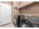 Modern laundry room featuring washer, dryer, and overhead storage shelf at 2580 E Boston St, Gilbert, AZ 85295