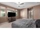 Main bedroom with ceiling fan, windows, and tv at 2580 E Boston St, Gilbert, AZ 85295