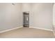 Neutral bedroom with carpet, white trim, and a hallway entry with an arched doorway at 26015 N 85Th Dr, Peoria, AZ 85383