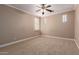 Bedroom featuring neutral colored walls, carpeted flooring, ceiling fan, and natural lighting at 26015 N 85Th Dr, Peoria, AZ 85383
