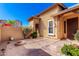 Private courtyard featuring desert landscaping, a built in firepit, and an arched stone entrance at 26015 N 85Th Dr, Peoria, AZ 85383