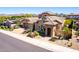 Elegant desert home with lush desert landscaping, a tile roof and spacious driveway leading to the two-car garage at 26015 N 85Th Dr, Peoria, AZ 85383