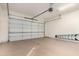 A clean garage with a light-colored floor and a white garage door with rails above at 26015 N 85Th Dr, Peoria, AZ 85383