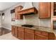 A charming kitchen featuring granite counters, a gas cooktop and travertine tile backsplash at 26015 N 85Th Dr, Peoria, AZ 85383