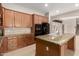Kitchen features granite countertops, tiled backsplash, island with sink, and black appliances at 26015 N 85Th Dr, Peoria, AZ 85383