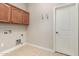 Laundry room with overhead storage cabinets, tile flooring, and utility connections at 26015 N 85Th Dr, Peoria, AZ 85383