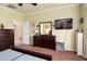 Carpeted bedroom with dresser, a TV, and neutral-toned walls at 26840 W Irma Ln, Buckeye, AZ 85396