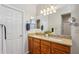 Bright bathroom featuring double sinks with granite counters and a large mirror with modern lighting at 28351 N 130Th Dr, Peoria, AZ 85383