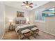 Stylish bedroom with a queen bed, unique artwork, and a window with plantation shutters at 28351 N 130Th Dr, Peoria, AZ 85383