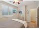 Well-lit bedroom featuring a ceiling fan, shutters, mounted TV, and mirrored closet at 28351 N 130Th Dr, Peoria, AZ 85383