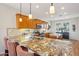 Spacious kitchen featuring granite countertops, wooden cabinets, stainless steel appliances, and a breakfast bar at 28351 N 130Th Dr, Peoria, AZ 85383