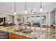 Open kitchen with granite countertops, seating at the bar, and views into the dining and living areas at 28351 N 130Th Dr, Peoria, AZ 85383