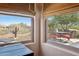Views from inside to an outdoor patio with a table and chairs, showcasing the desert landscape at 28351 N 130Th Dr, Peoria, AZ 85383